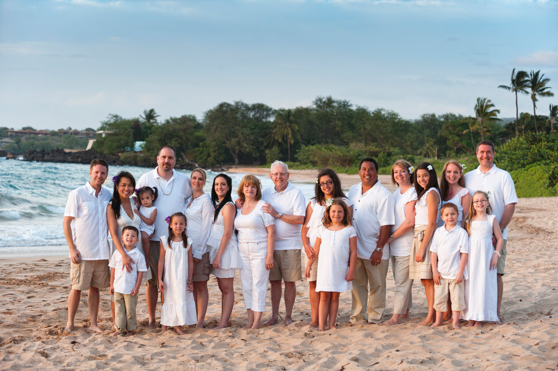 Family taking a group photo on a beach during a family reunion cruise in The Caribbean.